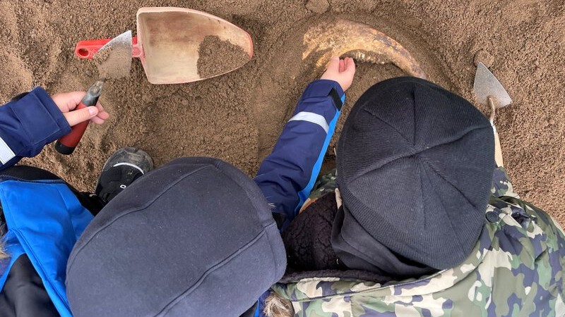 Nærfoto av to barn som graver i sand