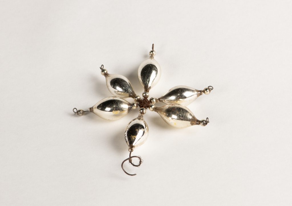 Foto av stjerneformet juletrepynt på hvit bakgrunn.