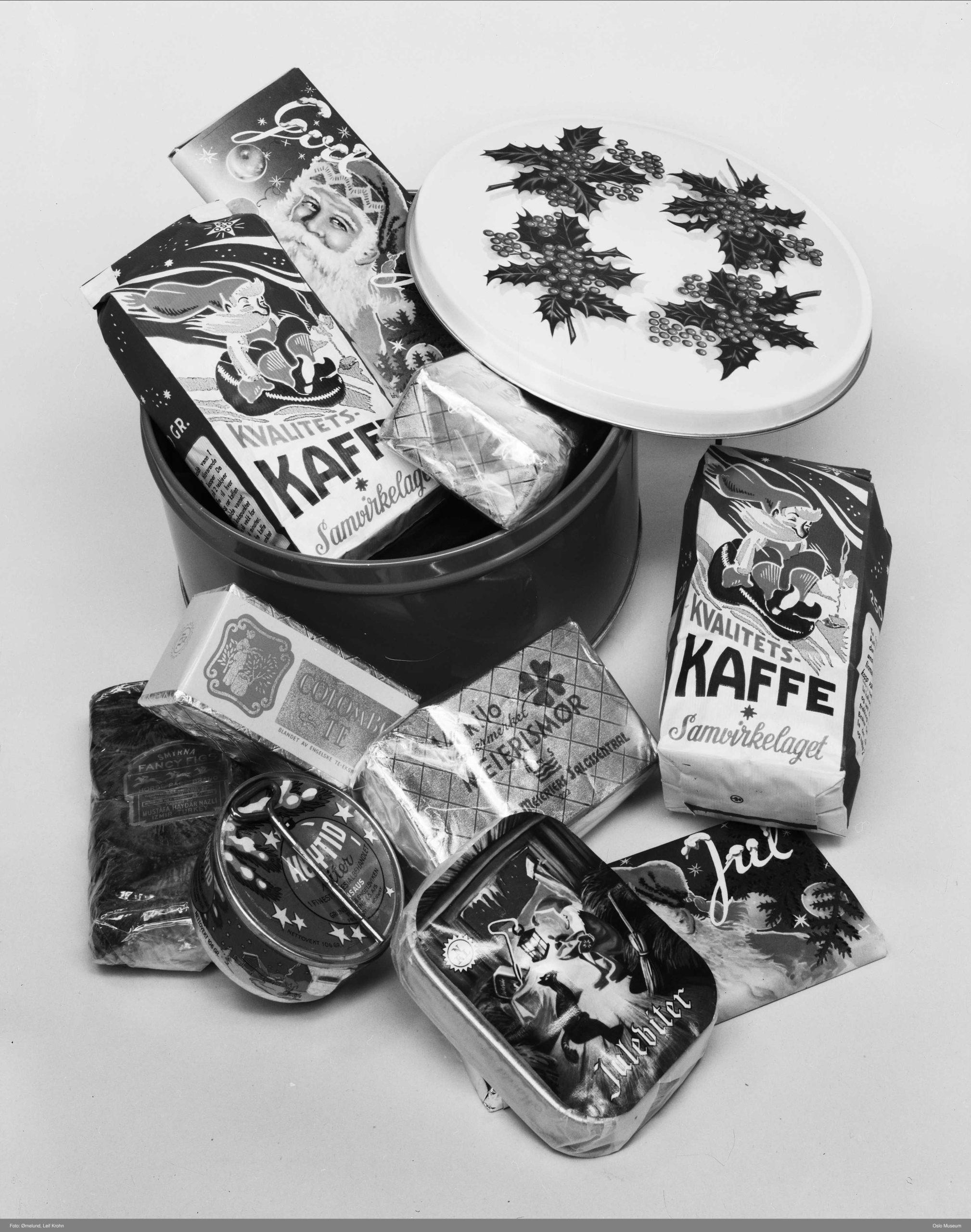 Foto av kaffe, meierismør, te og andre julevarer, i og ved siden av en kakeboks.