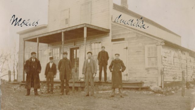Norway Lake Post Office i Jericho, Vermont, USA. Svart-hvittfoto av seks menn foran en bygning