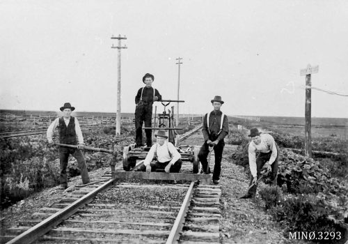 Eksempel fra USA: Rallargjeng, fotografert mellom 1890 og 1935. Svart-hvittfoto av fem menn med dresin og arbeidsverktøy på en togskinnegang